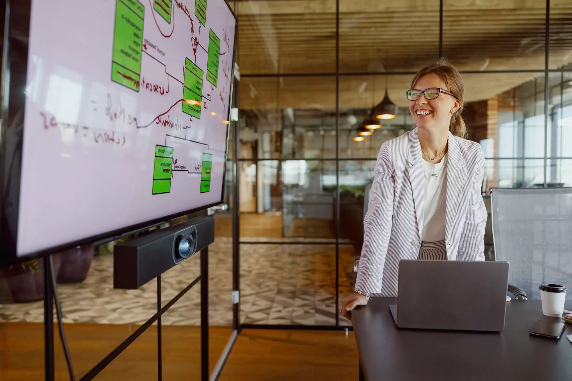 Professional presenting a process diagram on a large screen in a modern office.