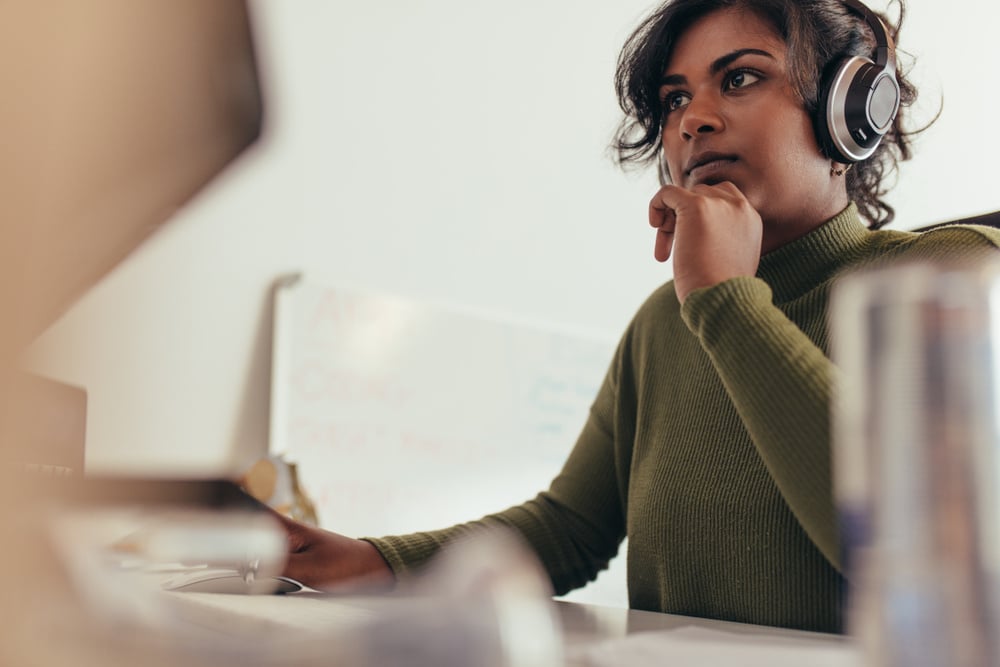 Professional working at computer screen with headphones. 